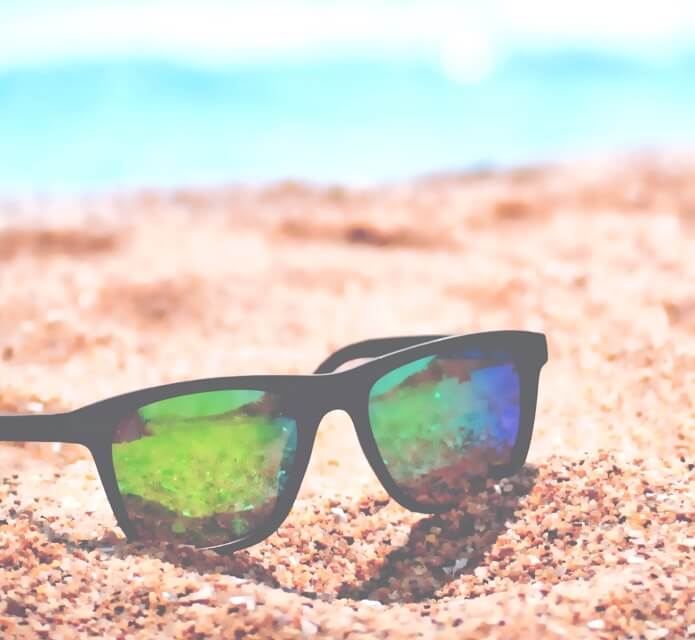 sunglasses placed on a sandy beach