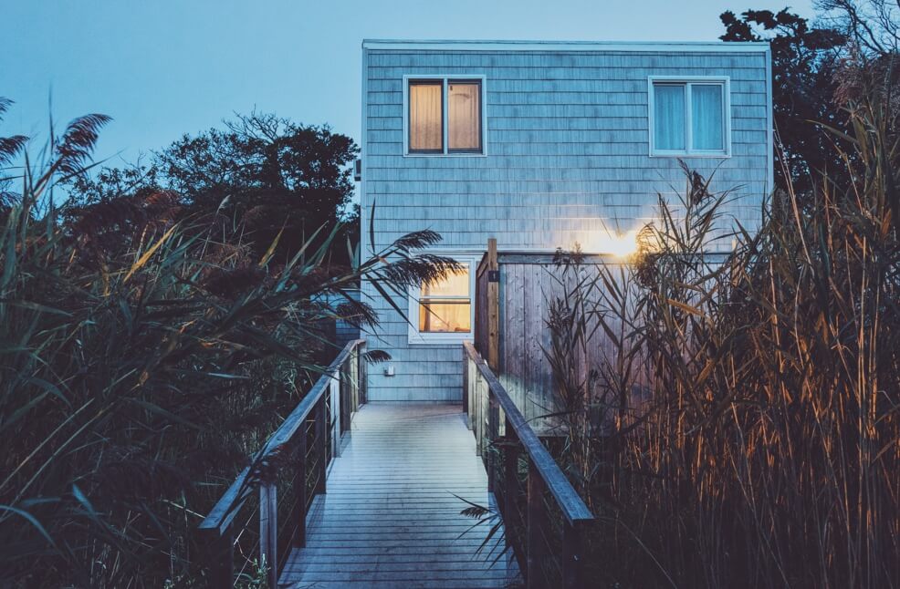 leafy walkway leading into a beach house in the evening
